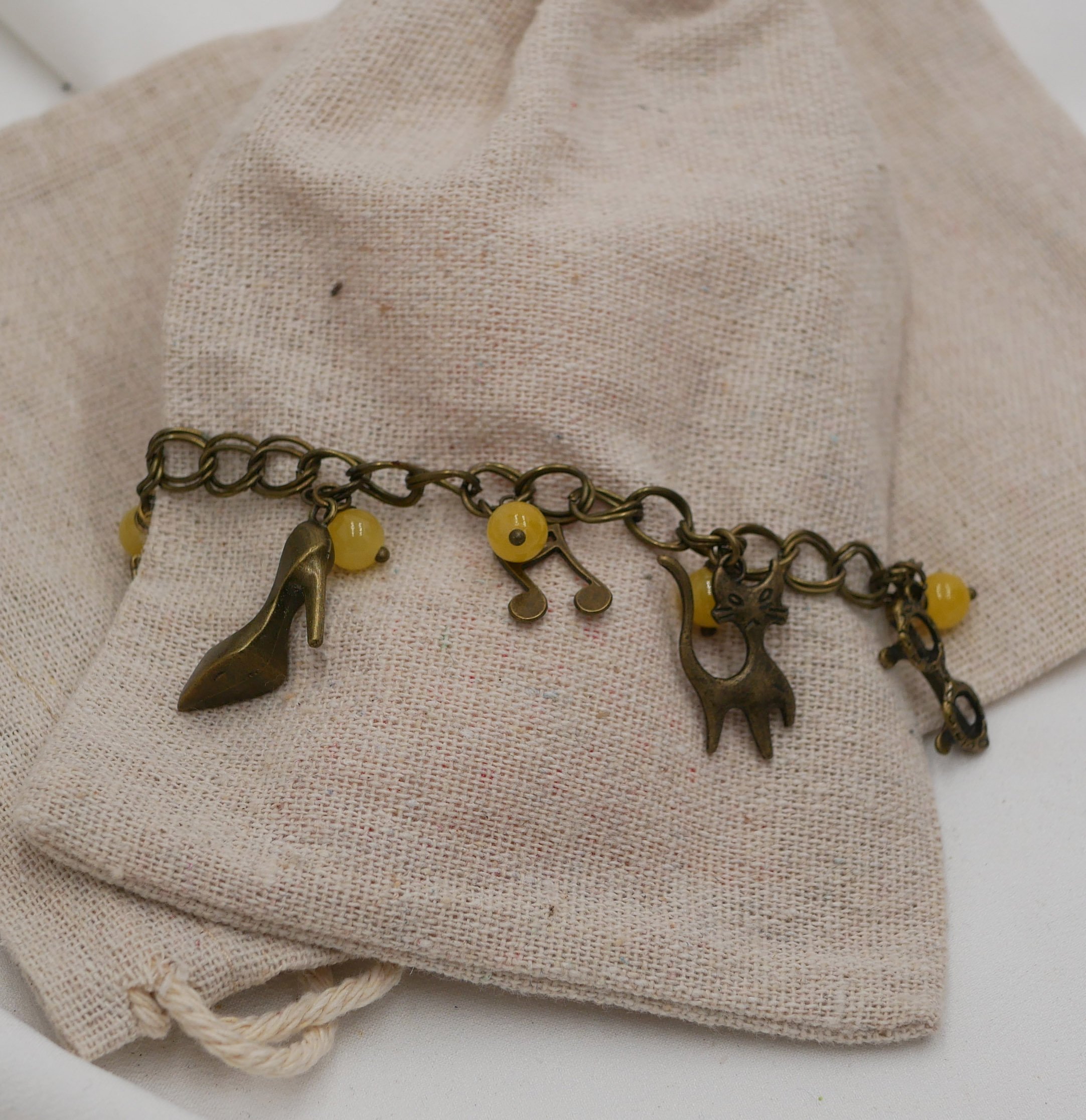 Bracelet aux breloques et perles jaunes sur cha&icirc;ne aux larges anneaux doubles