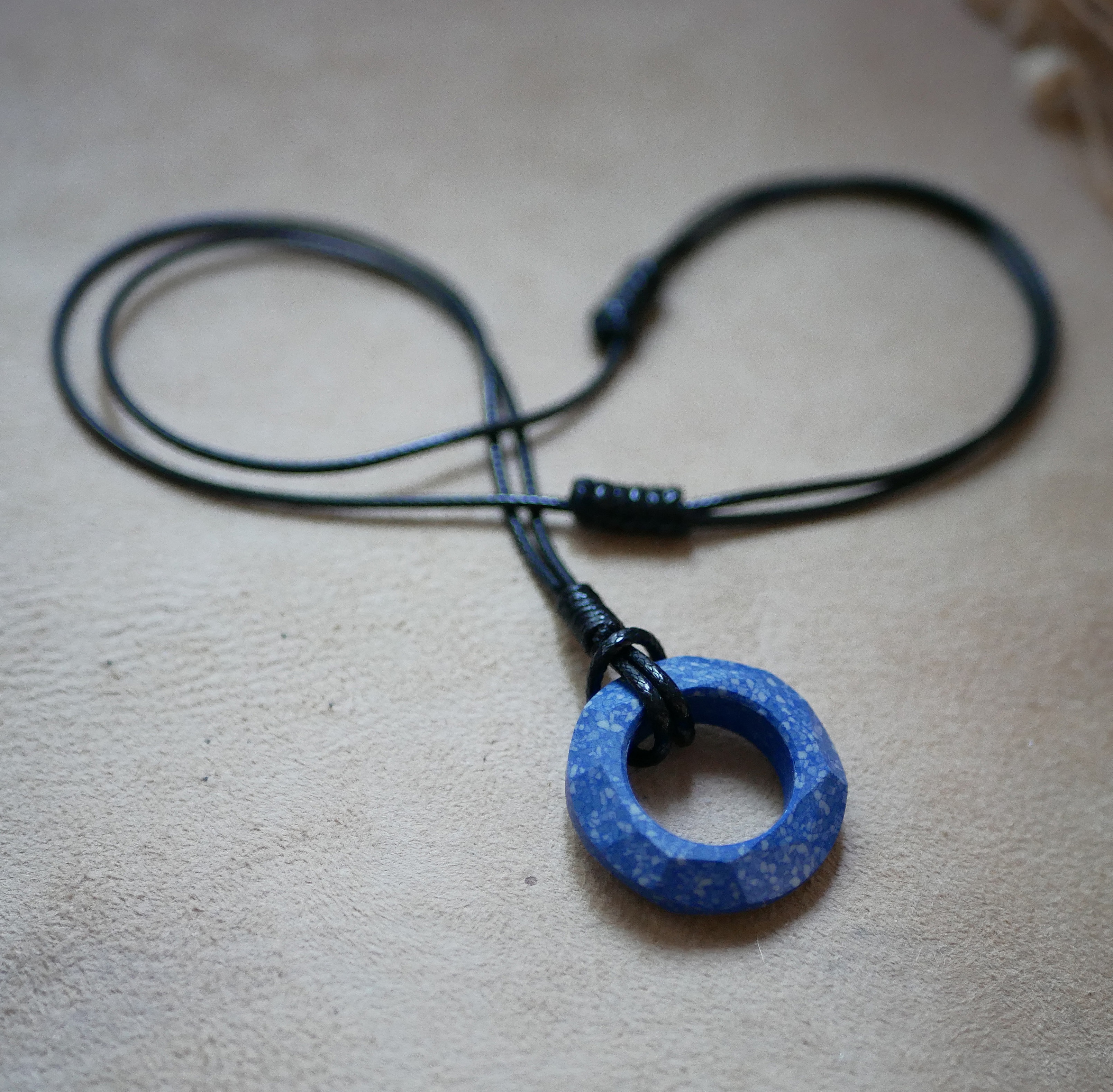 Collier anneau en c&eacute;ramique bleue sur cordon cuir noir ajustable